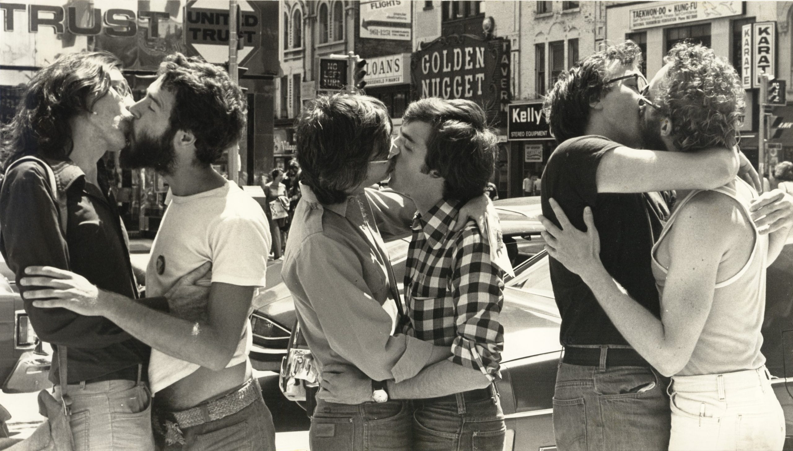 [Kiss-in at the corner of Yonge and Bloor, Toronto, 1976. Collection of the Canadian Gay and Lesbian Archives, Toronto.]