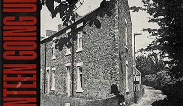Black and white image of a brick home with Seventeen Going Under on the side in red
