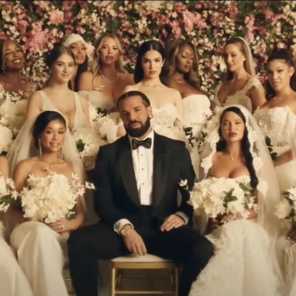 Drake in a black tux, sitting with a crowd of women in wedding dresses