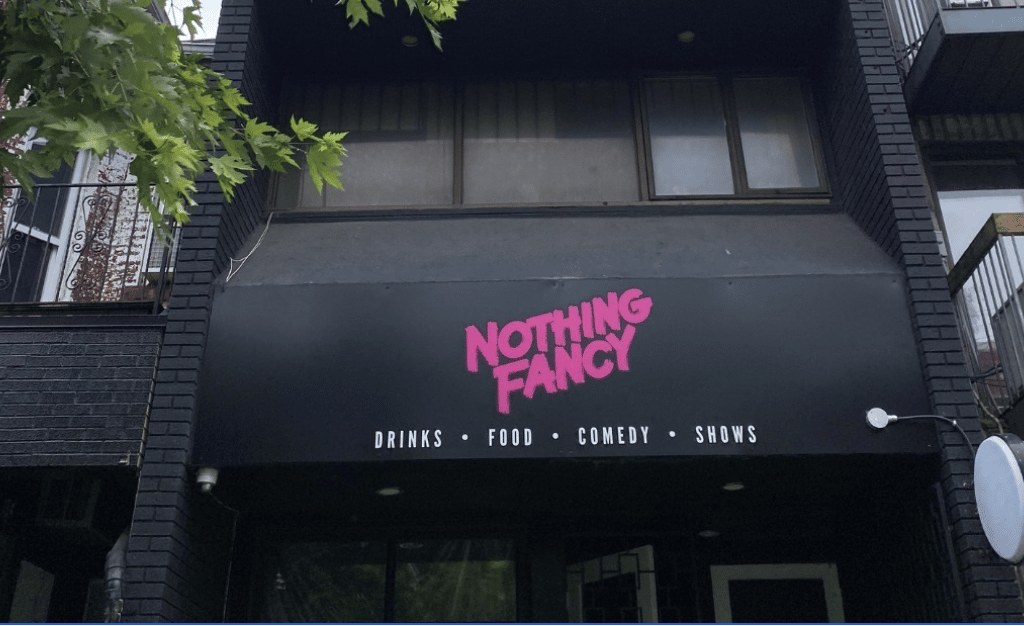 A shot of the exterior of Nothing Fancy's new Kensington Market location, which has a black banner with the bar's name written in hot pink