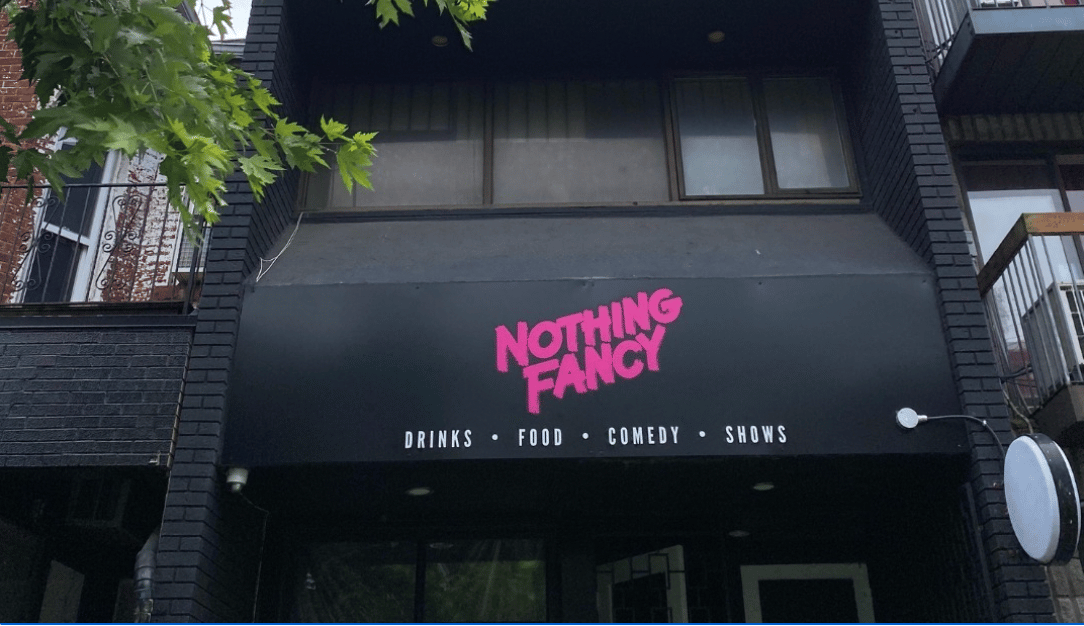 A shot of the exterior of Nothing Fancy's new Kensington Market location, which has a black banner with the bar's name written in hot pink
