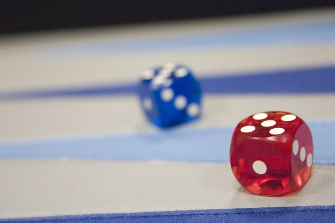 A red and a blue die on a generic game board
